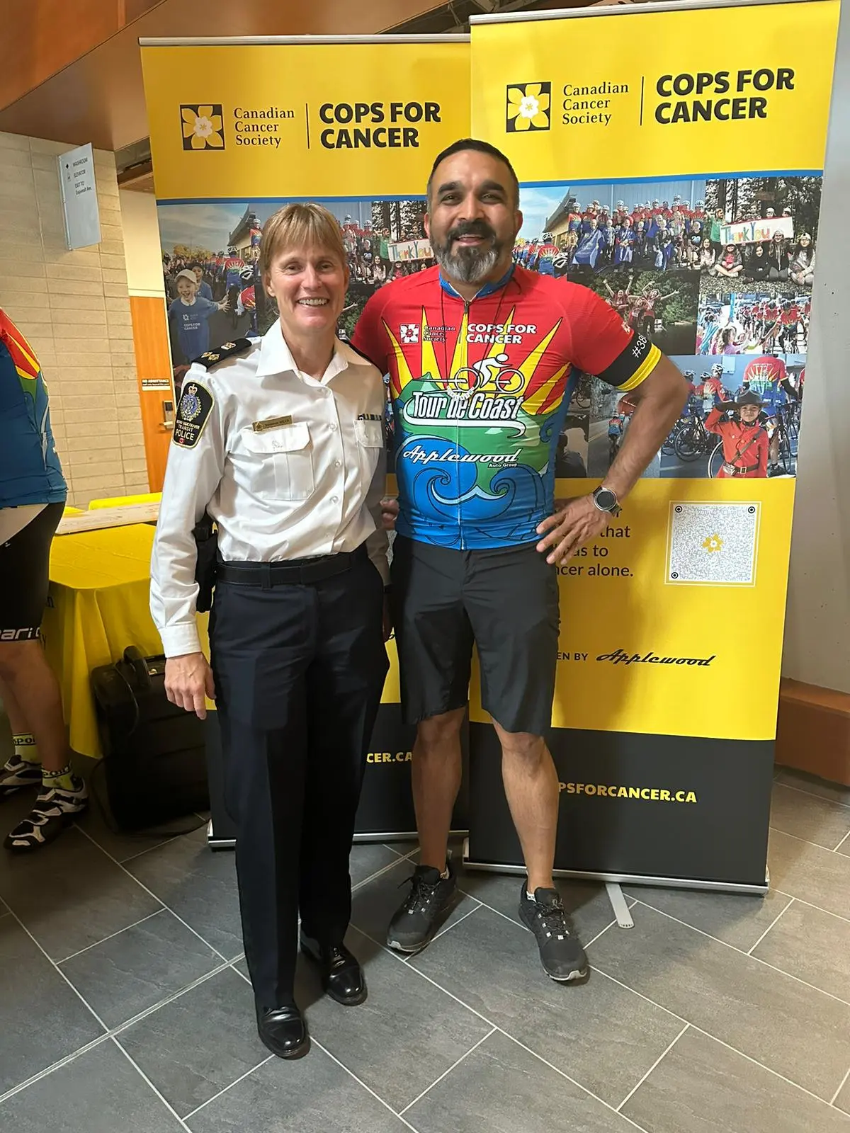 Transit Police Deputy Chief Officer Muir smiles at the camera with Sergeant Dal Deol who is wearing 'Cops for Cancer' gear